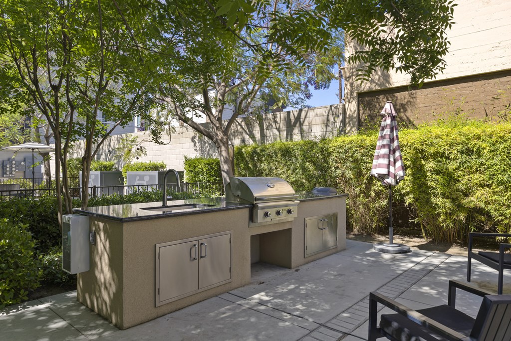 A small outdoor kitchen with a grill and sink.